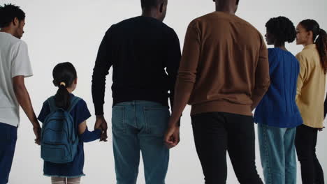 diverse group of adults and children holding hands, ready for school
