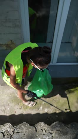mujer limpiando la basura en una calle de la ciudad