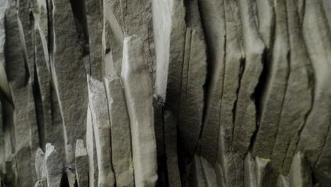 rocky wall with unique hexagonal pattern in a wet cave in iceland