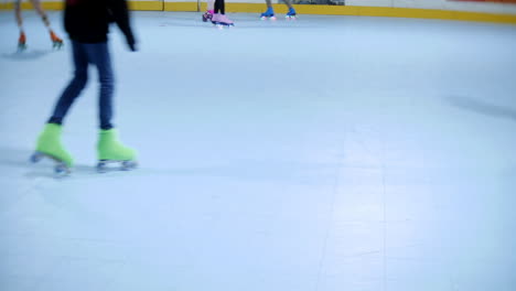 a croup of children and teenagers having fun skating at a roller skate rink