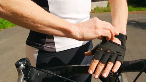 Senior-cyclist-wearing-fingerless-gloves-at-countryside-4k