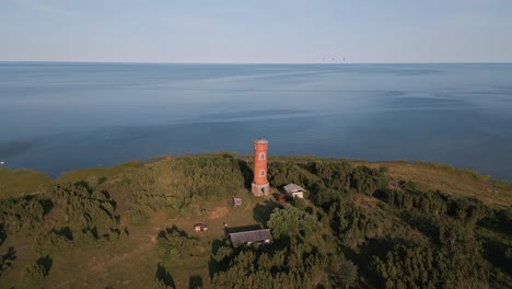 Fly-away-aerial-drone-flight-from-old-lost-place-lighthouse-at-the-coast-of-baltic-sea---Estonia-in-Europe---nature-helicopter-flyover-establishing-shot-summer-2022---bird-view