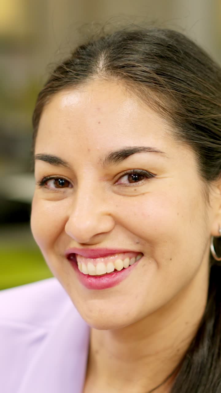 Smiling woman looking at camera sitting in a coworking