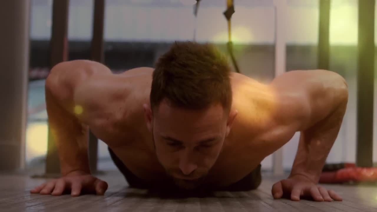 animación de manchas brillantes sobre un hombre fuerte haciendo ejercicio en el gimnasio