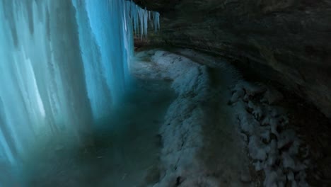 Caminata-Por-Un-Sendero-Congelado-Hacia-Una-Cueva-Detrás-De-Una-Hermosa-Cascada-Azul-Congelada-En-Minnesota