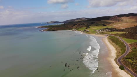 road to kaka point on new zealand east coast aerial tilt down fly backward shot