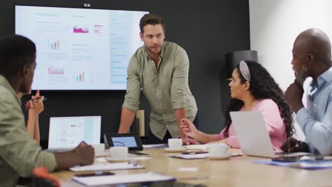 Happy-diverse-business-people-discussing-work-during-meeting-at-office