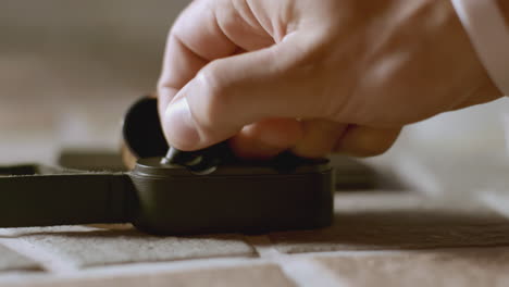 person putting earbuds into charging case