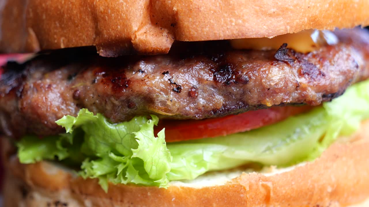primer plano de una jugosa hamburguesa de carne de res con lechuga y tomate