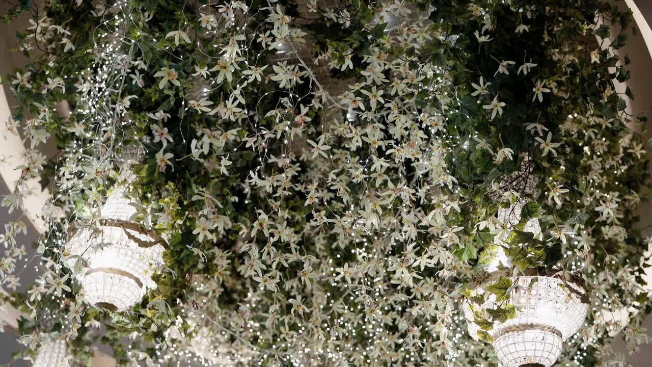 lush floral ceiling with crystal chandeliers and warm ambient lights