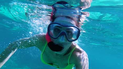 mujer joven buceando cerca de la superficie en aguas cristalinas del mediterráneo