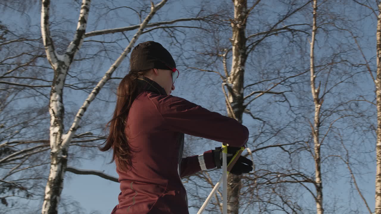 겨울 숲에서 크로스컨트리 스키를 타는 여자