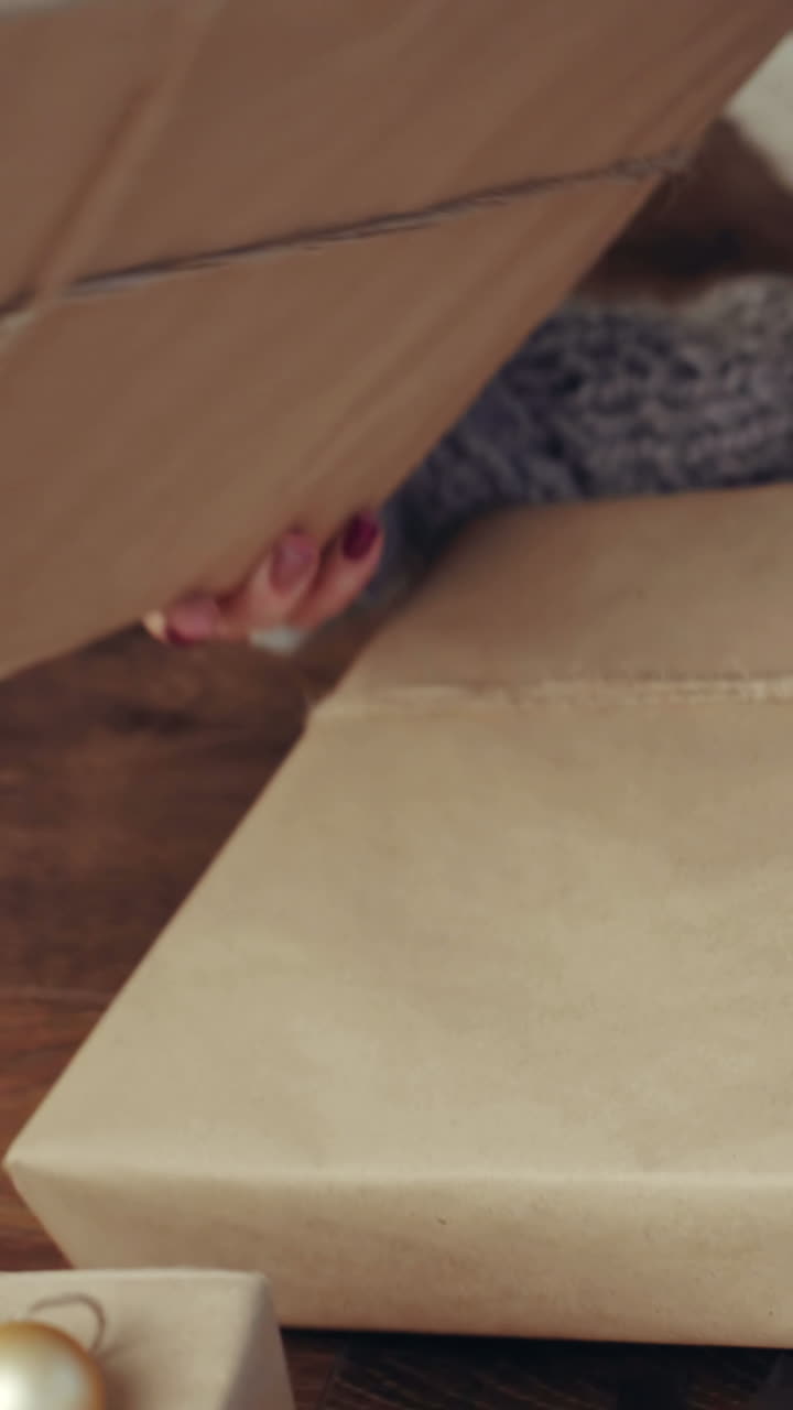 Gift Box New Year Day Celebration. Young attractive woman with gift box near fireplace Vertical video
