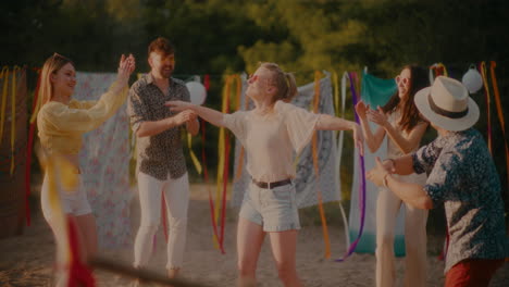 Carefree-woman-dancing-surrounded-by-friends-cheering-her