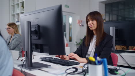 mujer trabajando en computadora en un entorno de oficina