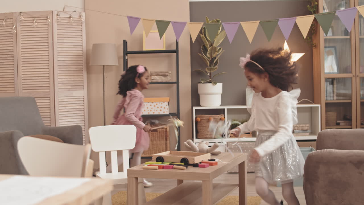 Mixed-Race Sisters Running Around Room