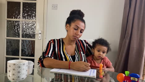 Young-Woman-with-Small-Child-On-Business-Video-Call-Listening-Intently-Whilst-Looking-Directly-to-Camera