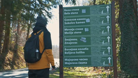 the hiker looking at mountain signpost 4k