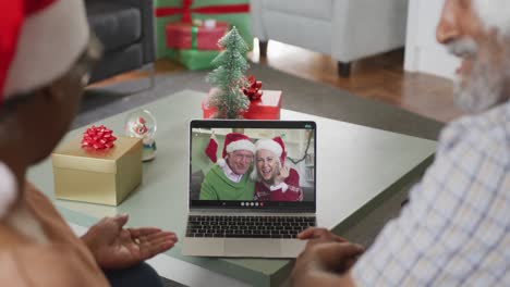 Happy-african-american-senior-couple-on-video-call-with-senior-friends-at-christmas