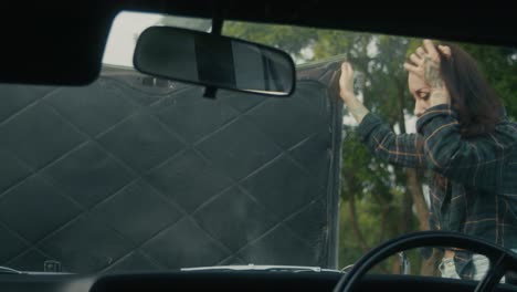 una mujer arreglando un coche averiado.