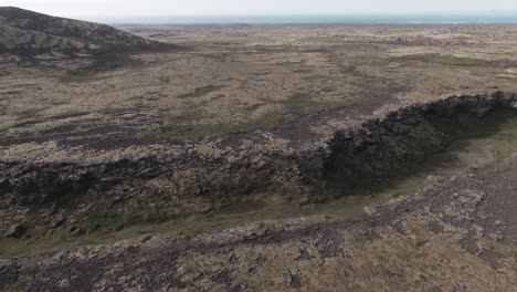 Flying-above-crater,-lava-fields,-wild-river-in-Snaefellsjokull-park
