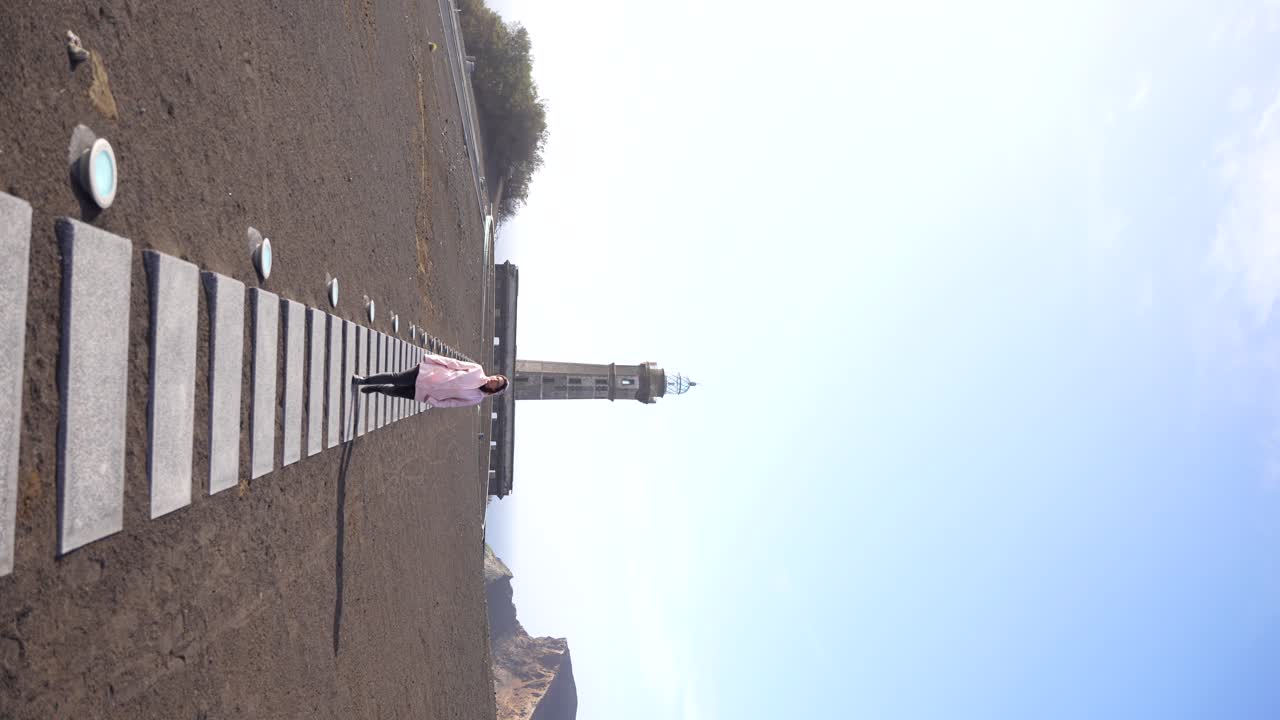 화산 재 위 를 고 있는 여자 와 배경 에 있는 파롤 다 폰타 도스 카펠린호스, 파이알, 아조레스