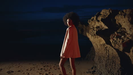 sexy girl modeling cliff shore at night. slim attractive woman posing dark beach