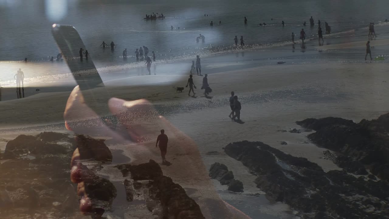 Mano di donna che tocca il telefono, sovrapposta a una costa con persone che camminano e la marea che si muove, per i travel designer.