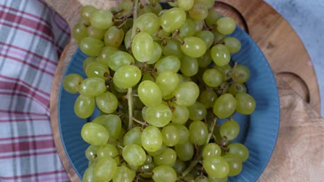 rotación circular un montón de uvas blancas en un plato, vista de arriba.