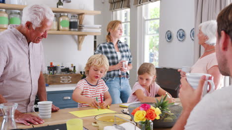 familia de varias generaciones hablando en casa en su cocina