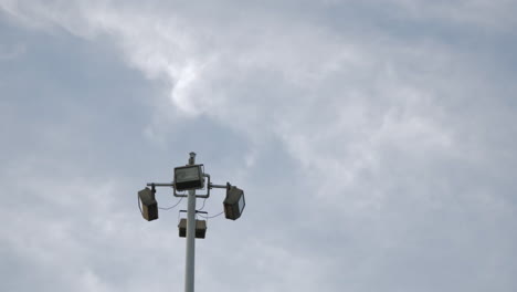 clouds in the sky flying above light post outdoor - low angle, time lapse