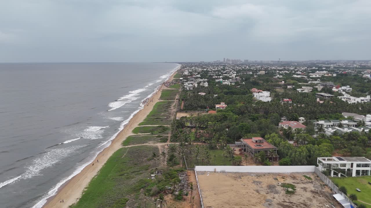 Long coastline framed by colorful rooftops and lush greenery in urban city