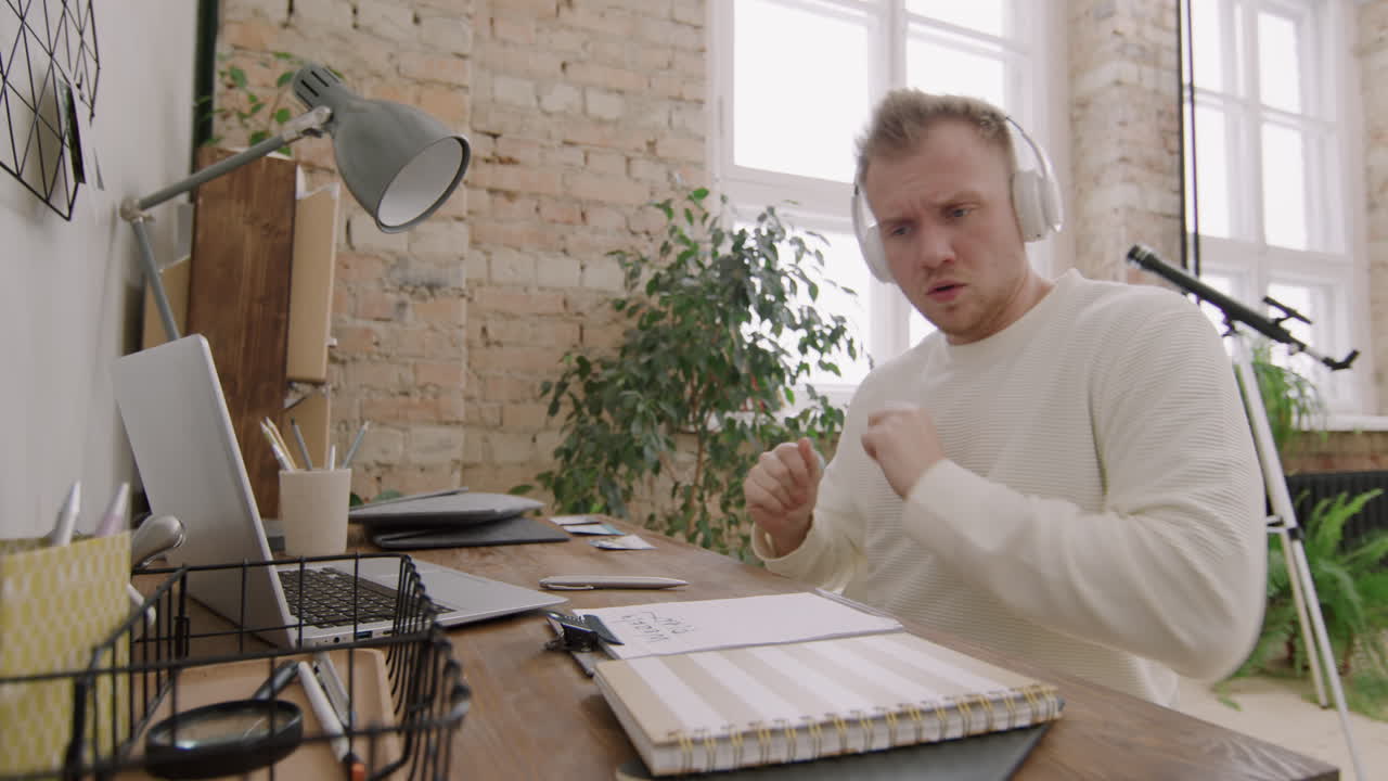 Energetic Man Dancing to Music and Looking at Laptop
