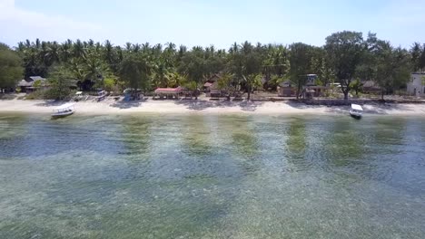 Paradise-lonely-dream-beach-with-palm-trees,-small-huts