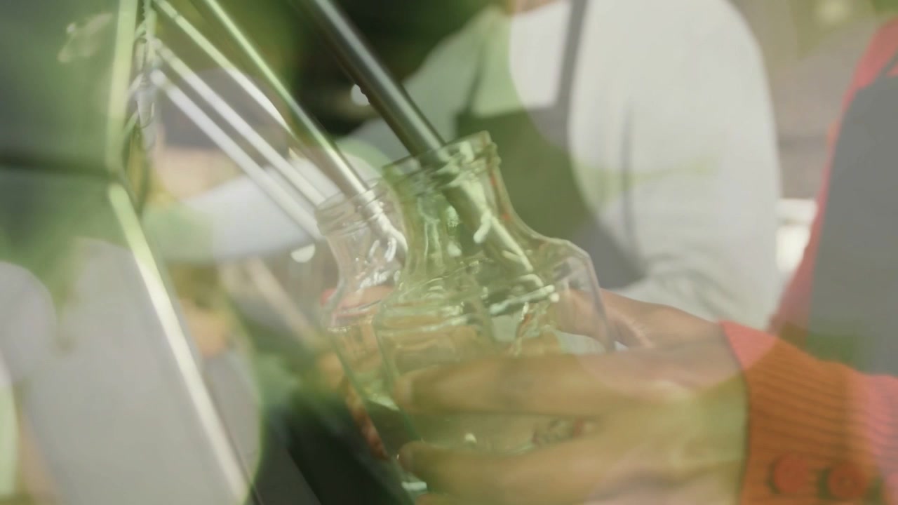 Close-Up of Hands Filling Small Glass Bottles with Clear Liquid