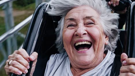mujer anciana disfrutando de un paseo en montaña rusa