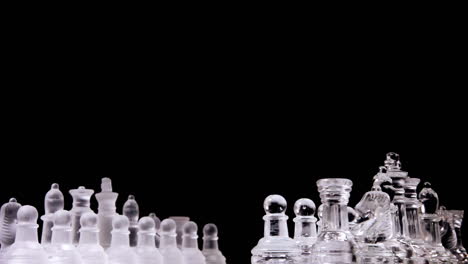 A-magnificent-chessboard-with-two-different-full-sets-of-chess-pieces-made-of-glass,-rotating-into-a-starting-position-for-one-player-to-the-equivalent-for-the-other