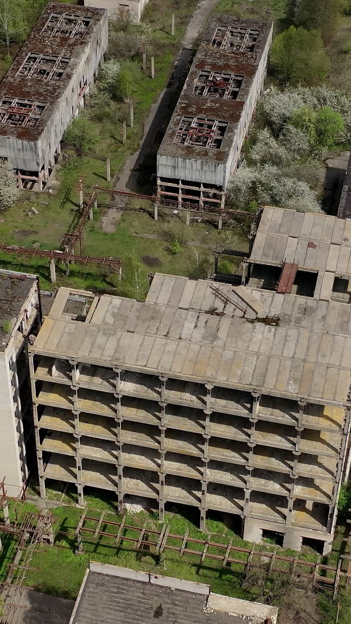 Aerial view of ruined old factory. Aerial shot of big abandoned factory. Vertical video