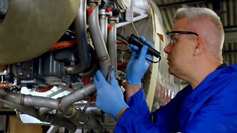 Engineer-examining-an-aircraft-engine-in-hangar-4k