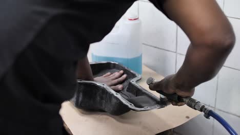 using a wire brush on a rotary tool to clean silicone gasket from car part