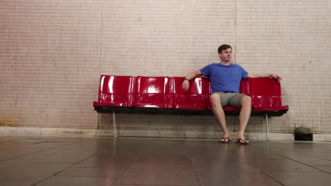 hombre sentado en el metro y revisando el teléfono