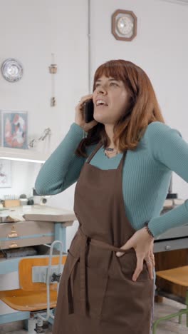 woman on a phone call in her workshop