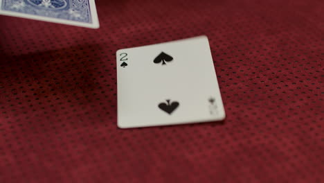 slow motion closeup of a card dealer revealing a two of spades on the game table