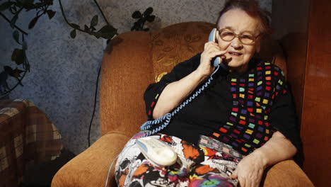 anciana recibiendo una llamada telefónica por la noche
