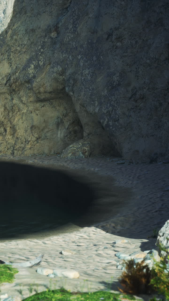 una cueva en un acantilado con vistas a una playa de arena