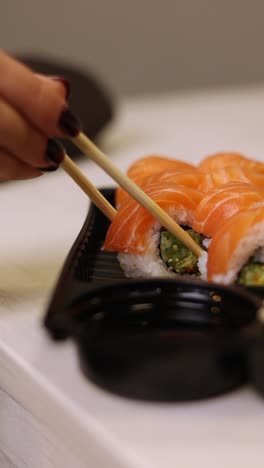 rollo de sushi de salmón con palillos