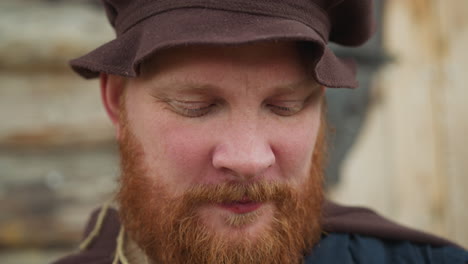 Red-bearded-man-in-medieval-clothes-drinks-potion-from-lid