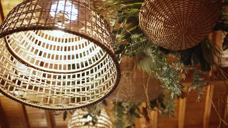handwoven wicker pendant lights with greenery in a rustic wooden ceiling