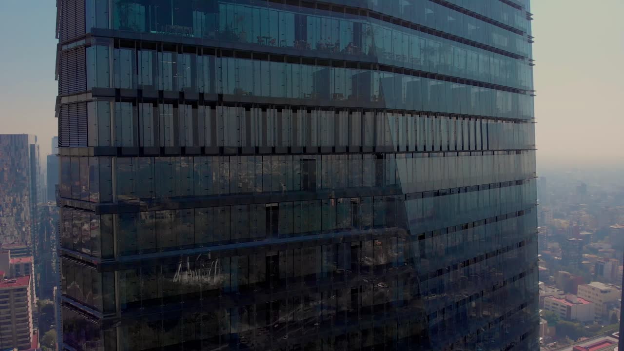 Drone subindo ao lado de um arranha-céu na Cidade do México, restaurante com terraço à luz do dia.