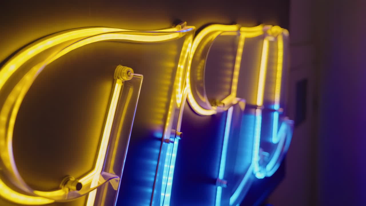 Close-up of a vibrant neon sign glowing in yellow and blue